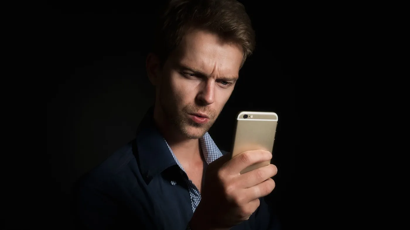 Écran d'ordinateur affichant deux logiciels de comptabilité côte à côte, gestionnaire VTC consultant des tableaux de bord avec données Uber, bureau avec documents et téléphone